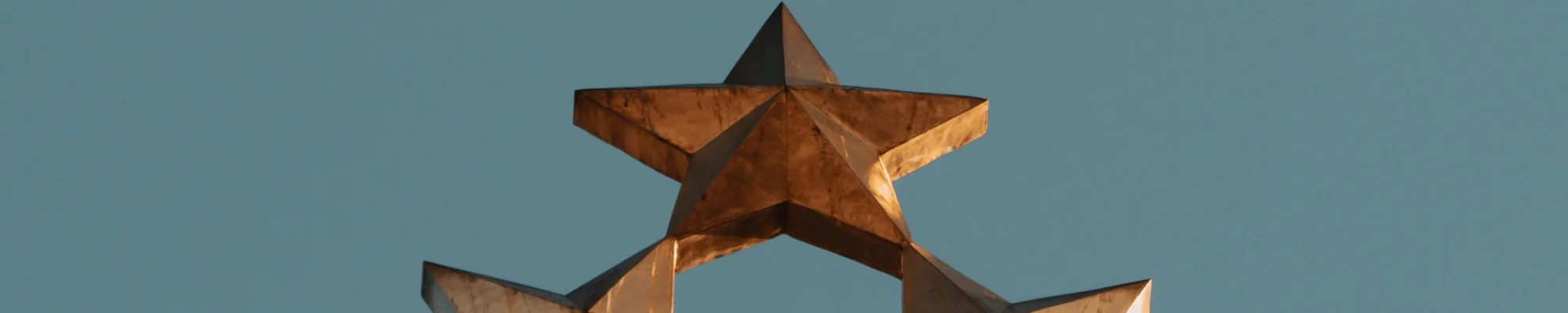 Gold metal stars on a blue sky background